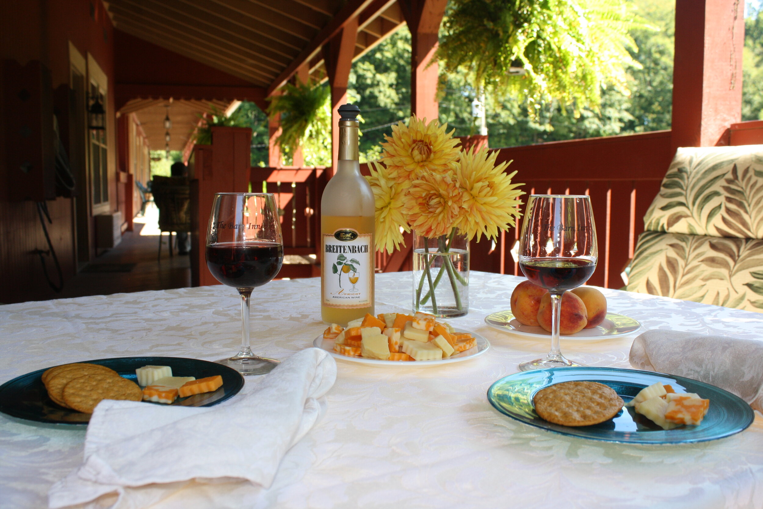 Wine and cheese on an outdoor deck with flowers